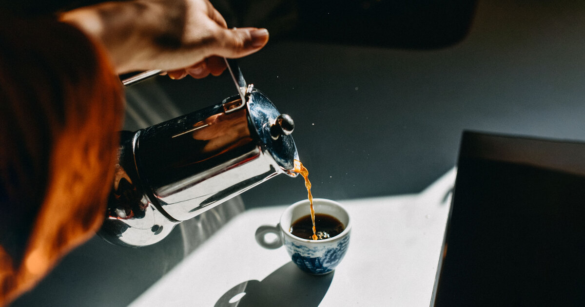 Чашка кофе на фоне размытого изображения кофейных зерен